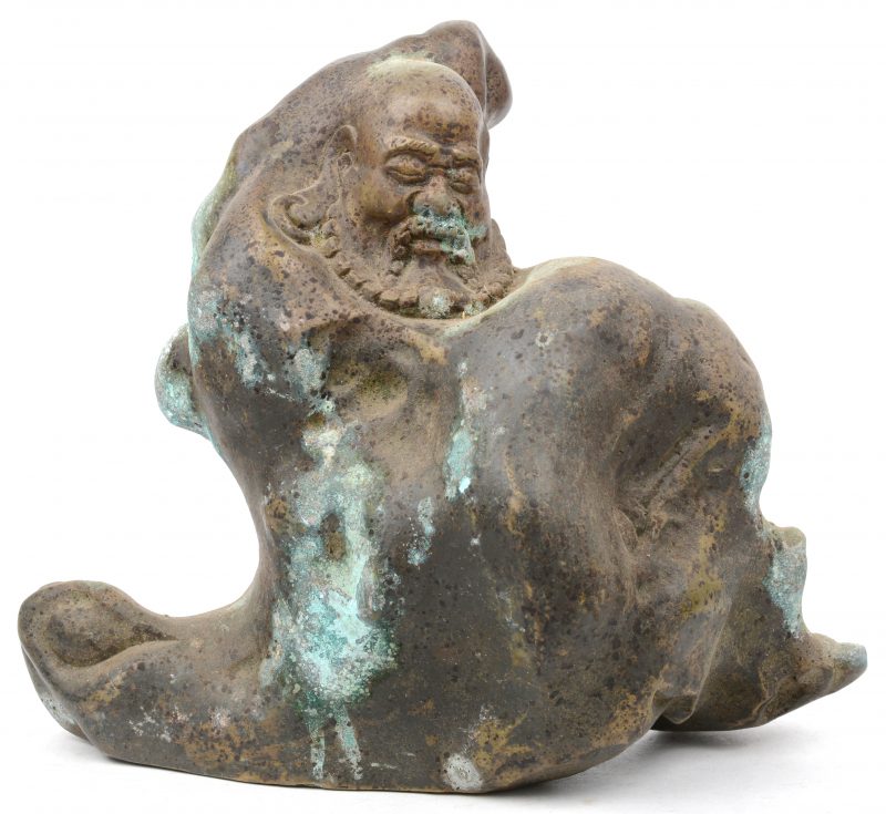 Een bronzen beeld van een man in een rots.