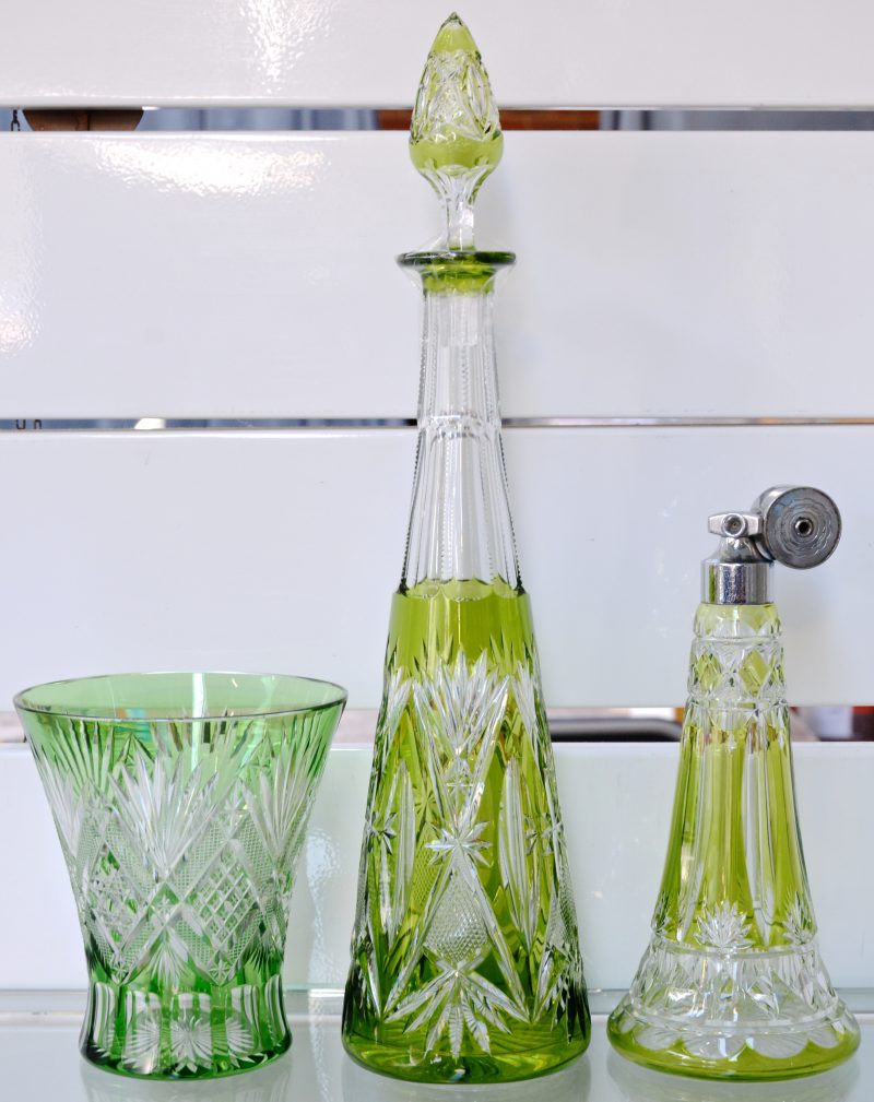 Een lot bestaande uit een vaas, karaf en verstuiver van groen gekleurd geslepen kristal.
