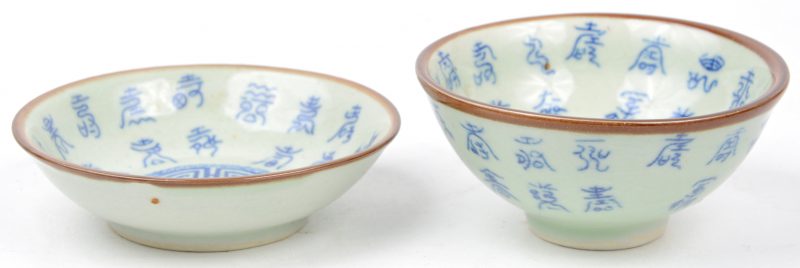 Een kommetje met schoteltje van Chinees porselein met een blauw decor van Chinese tekens. Onderaan gemerkt.