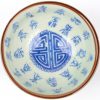 Een kommetje met schoteltje van Chinees porselein met een blauw decor van Chinese tekens. Onderaan gemerkt.