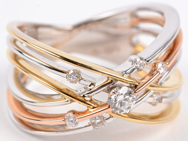 Een 18 karaats wit en geel gouden ring bezet met diamanten met een gezamenlijk gewicht van ± 0,28 ct.