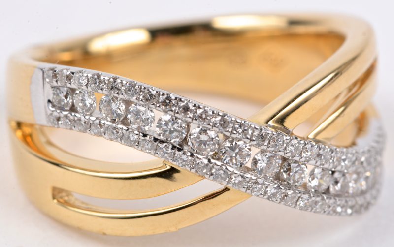 Een 18 karaats wit en geel gouden ring bezet met diamanten met een gezamenlijk gewicht van ± 0,58 ct.
