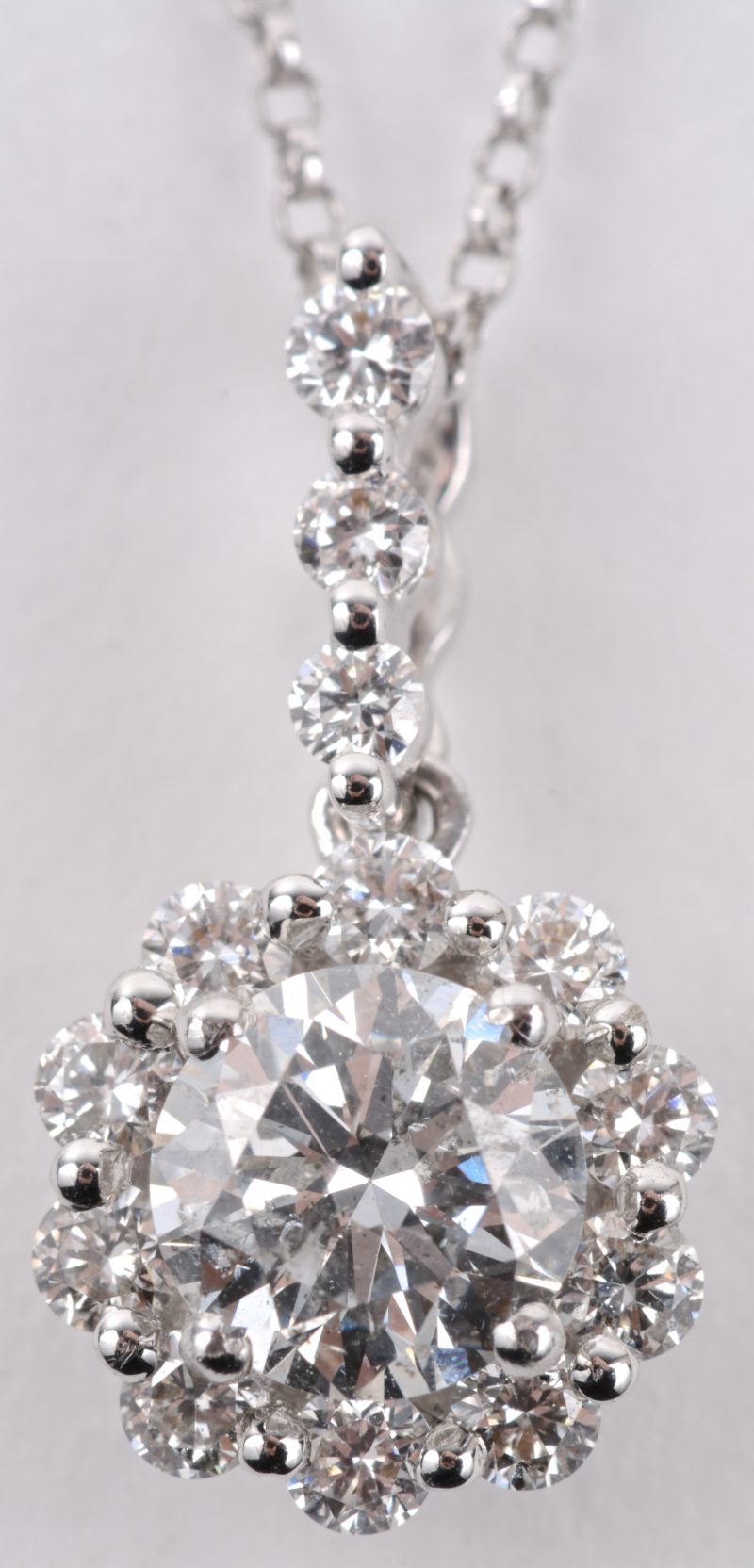 Een 18 karaats wit gouden ketting met hanger bezet met een centrale diamant van 0,72 ct. en diamanten met een gezamenlijk gewicht van ± 0,30 ct.