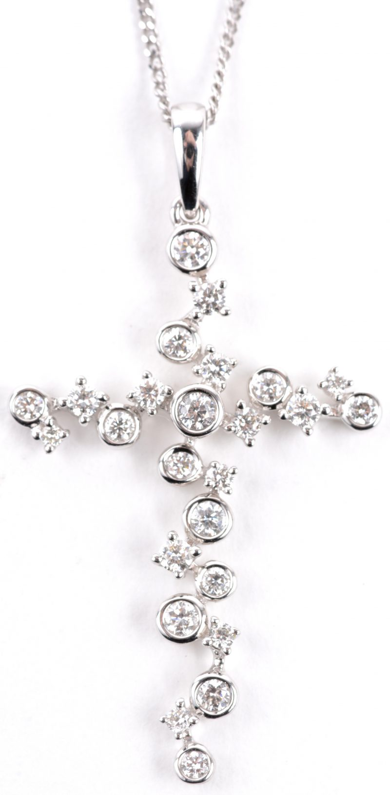 Een 18 karaats wit gouden ketting met hanger in de vorm van een kruis bezet met diamanten met een gezamenlijk gewicht van ± 0,36 ct.