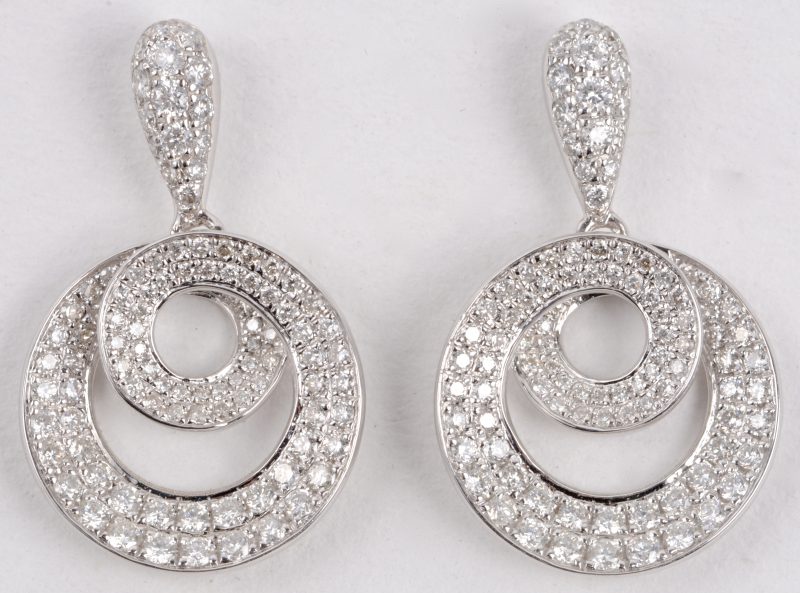 Een paar 18 karaats wit gouden oorbellen bezet met diamanten met een gezamenlijk gewicht van ± 1,05 ct.