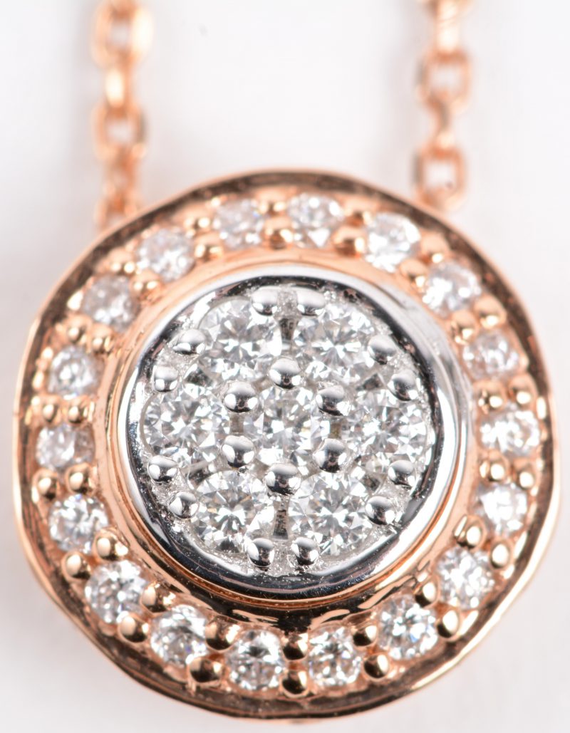 Een 18 karaats roze gouden ketting met hanger van wit en roze goud bezet met diamanten met een gezamenlijk gewicht van ± 0,20 ct.