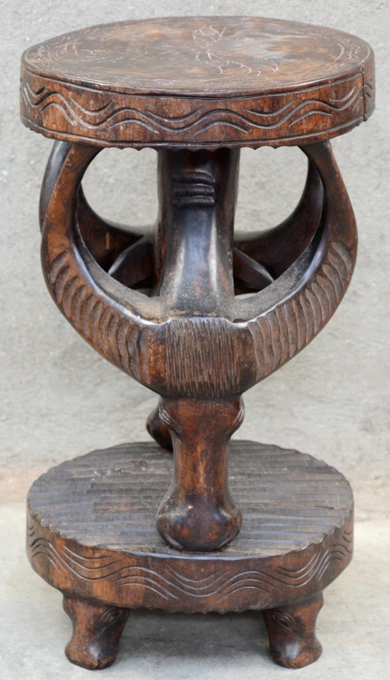Een gesculpteerd houten krukje in de vorm van twee buffelkoppen. Afrikaans werk.