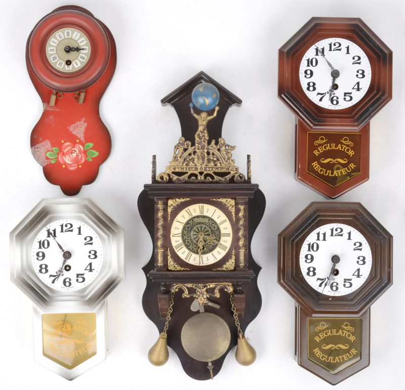 Een lot kleine klokjes, waarbij drie regulateurs en een Zaans klokje van kunststof en een houten klokje.