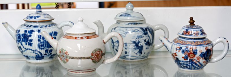 Vier diverse theepotjes van Chinees en Japans porselein. Eén met een toegevoegd dekseltje, één met een beschadigd dekseltje.