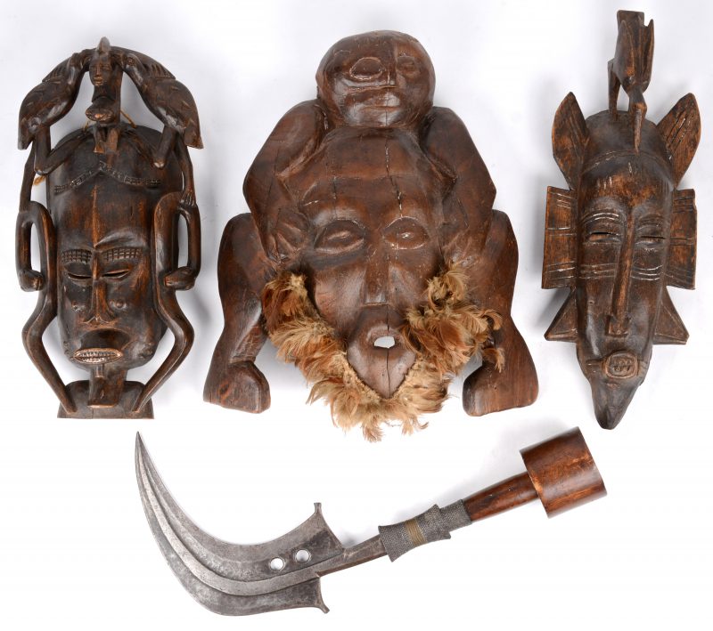 Lot Afrikaanse sculpturen: drie maskers en een ceremonieel mes.