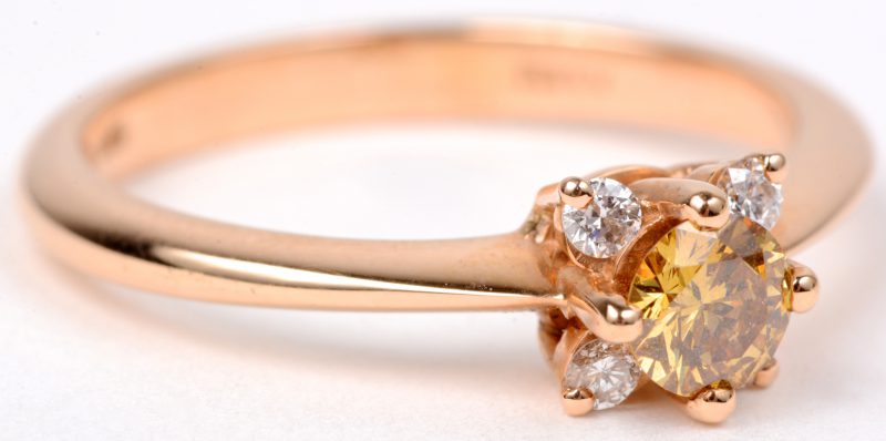 Een 18 karaats roze gouden ring bezet met diamanten met een gezamenlijk gewicht van ± 0,10 ct. en een centrale gele diamant van ± 0,25 ct.