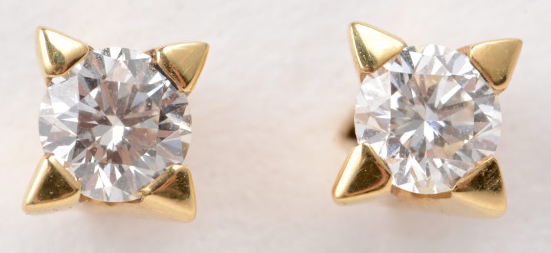 Een paar 18 karaats geel gouden oorbellen bezet met diamanten met een gezamenlijk gewicht van ± 0,36 ct.
