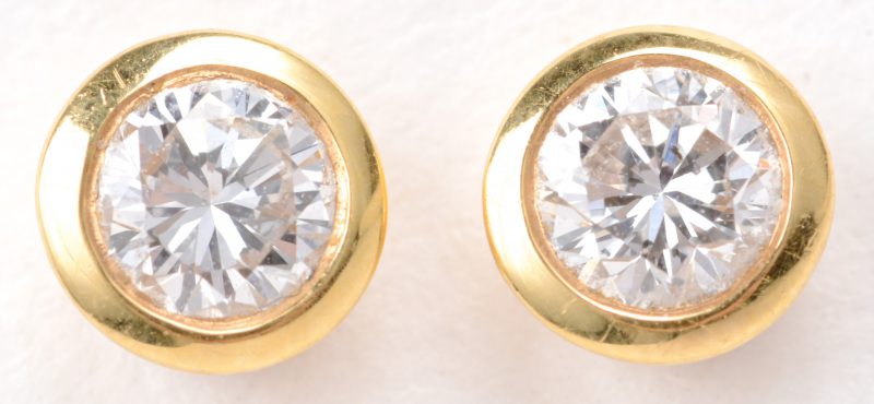 Een paar 18 karaats geel gouden oorbellen bezet met diamanten met een gezamenlijk gewicht van ± 0,40 ct.