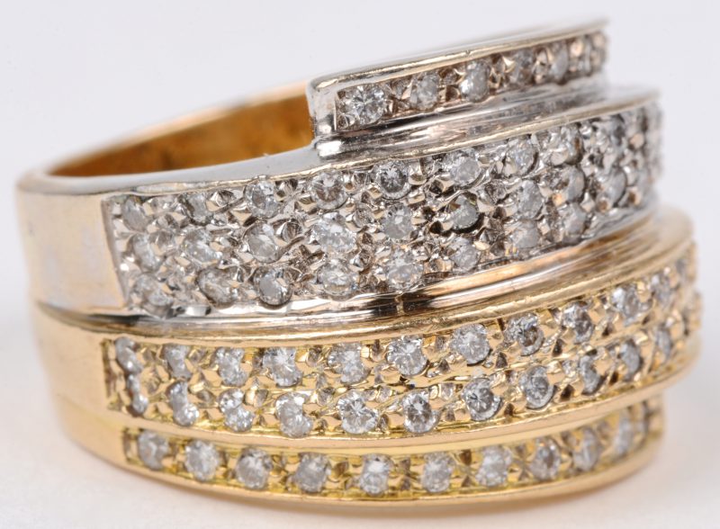 Een 18 karaats wit en geel gouden ring bezet met briljanten met een gezamenlijk gewicht van ± 1,20 ct.
