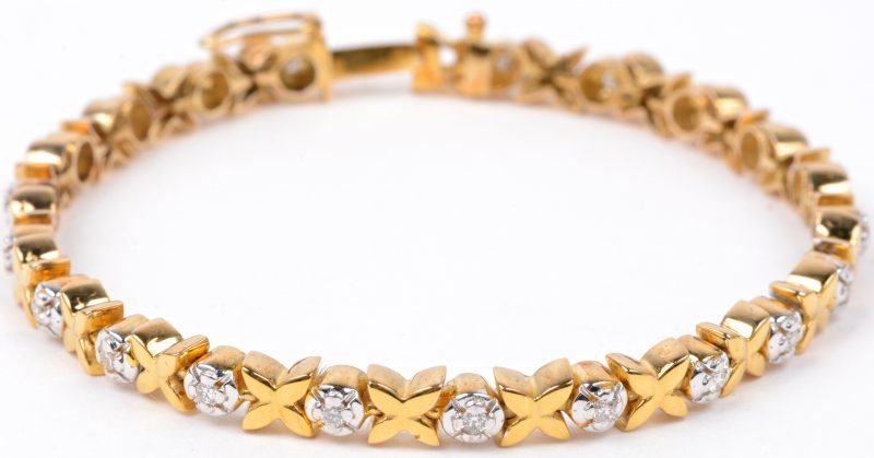 Een 14 karaats wit en geel gouden armband bezet met briljanten met een gezamenlijk gewicht van ± 0,60 ct.