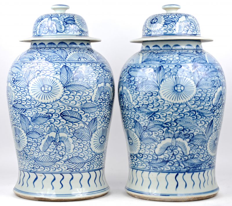 Een paar dekselvazen van Chinees porselein met een blauw op wit bloemendecor.