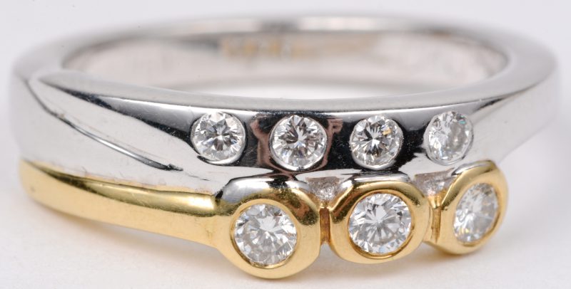 Een 18 karaats wit en geel gouden ring bezet met diamanten met een gezamenlijk gewicht van ± 0,35 ct.