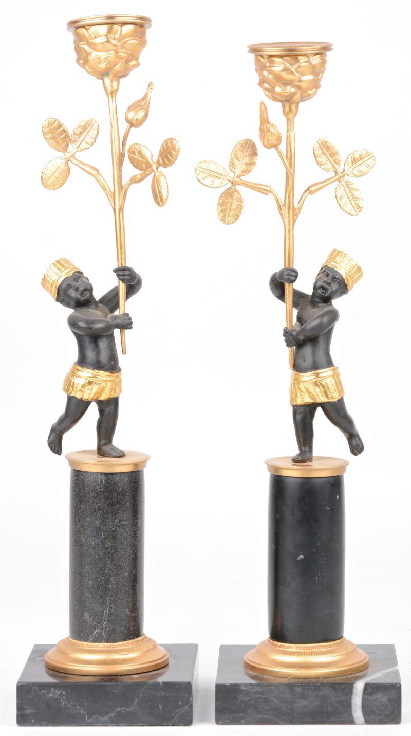 Een paar deels verguld bronzen kandelaartjes, gedragen door moriaantjes op arduinen sokkeltjes.