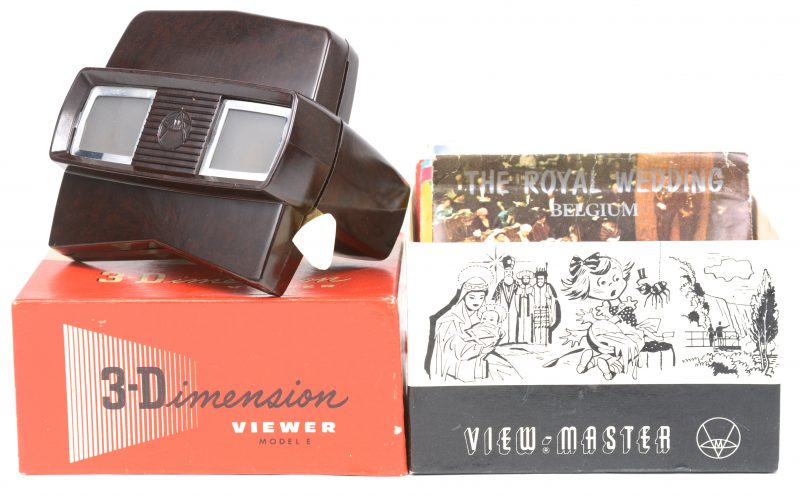 Een Viewmaster model E in originele doos met 4 etuis met telkens 3 schijfjes mbt Expo ‘58 én een zeldzaam schijfje mbt het Atomium, diverse schijfjes met zichten op Italië, Portugal, etc en 3 schijfjes mbt de Koninklijke familie uit 1976.