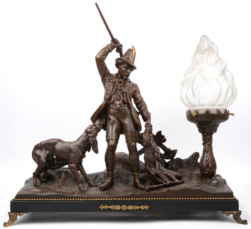 “Jagersscène”. Een bronzen groep met een lampje.