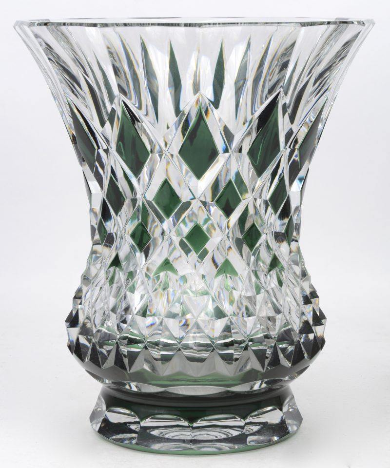 Een zware vaas van kleurloos en groen geslepen kristal met in ruitmotief geslepen decor. Onderaan gemerkt.