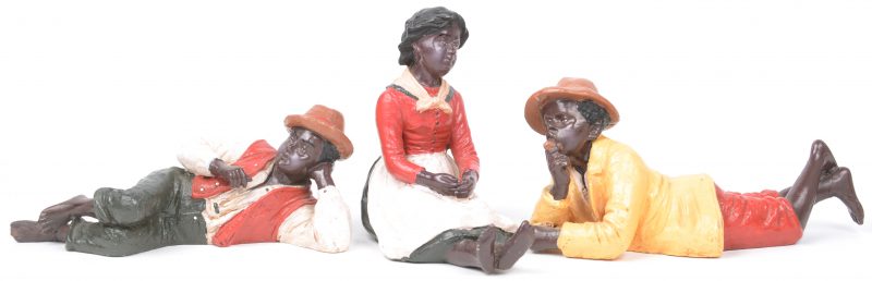Drie zg. slavenbeeldjes van gepolychromeerd gips.