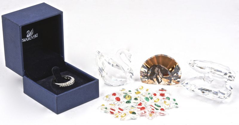 Een lot geslepen kristallen sierstukjes, bestaande uit een zwaantje, ééntje met een afbeelding van een leeuw, een schelp met parel en een zakje met kleine bloemetjesm en een ring van Swarovski.
