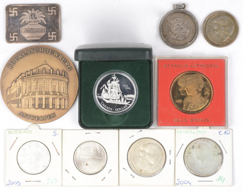 Een lot munten, bestaande uit een munt ter gedenking van het huwelijk van Diana en Charles, een 999‰ zilveren hindoeïstische plaquette, een munt van de Bourlaschouwburg, enkele speciale Nederlandse munten, een halve Amerikaanse Dollar en een zilveren Canadese Dollar.