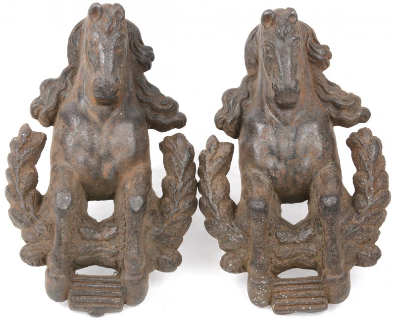 Twee ijzeren poortornamenten in de vorm van aanstormende paarden.