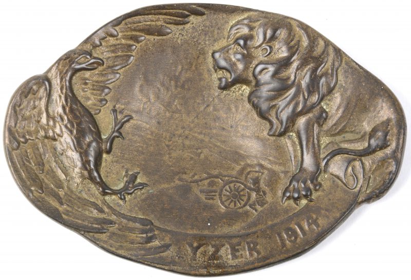 Een bronzen schaaltje met een oorlogsscéne geflankeerd door een arend en een leeuw met het opschrift ‘ Yzer 1914’.