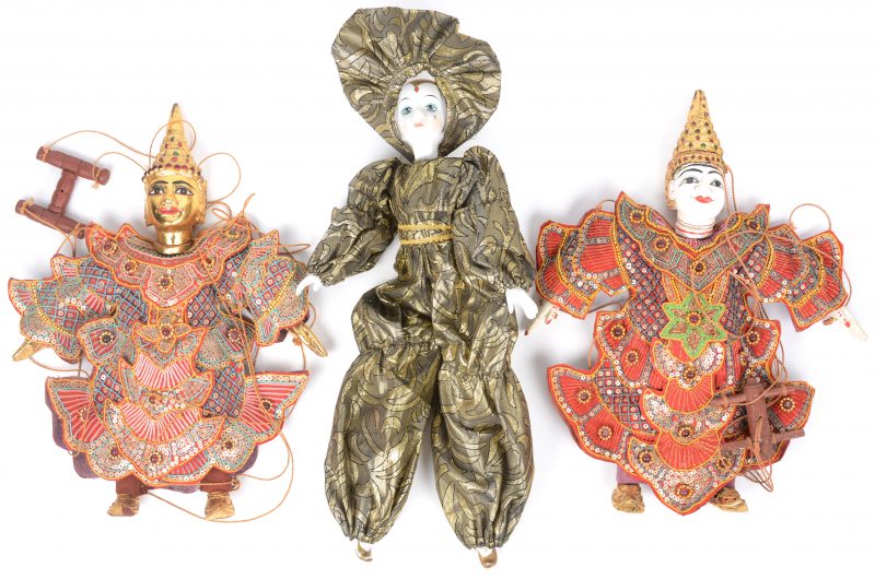 Een lot van drie poppen, waarbij twee Thaise en één met porseleinen hoofdje.