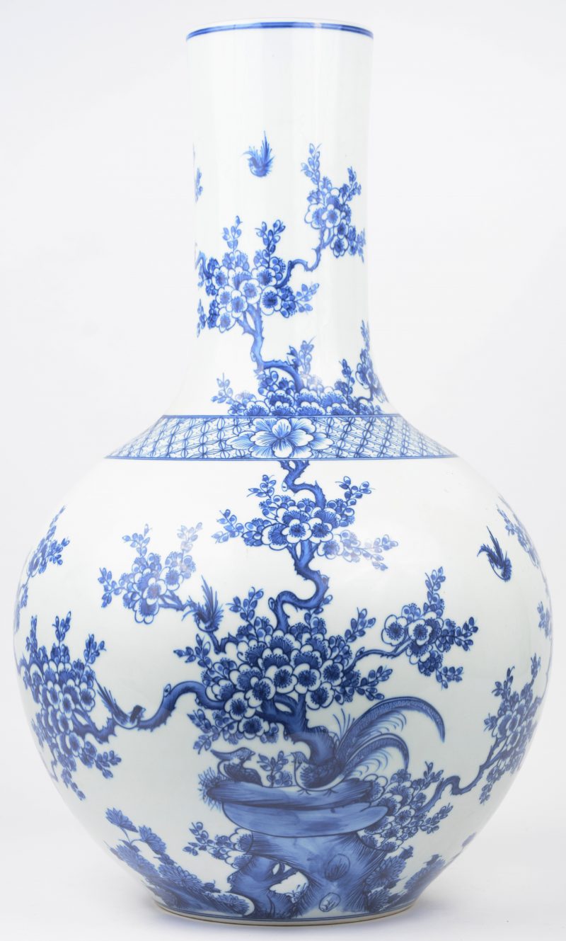 Een buikvaas van Chinees porselein met een blauw op wit decor van bloesems en vogels.