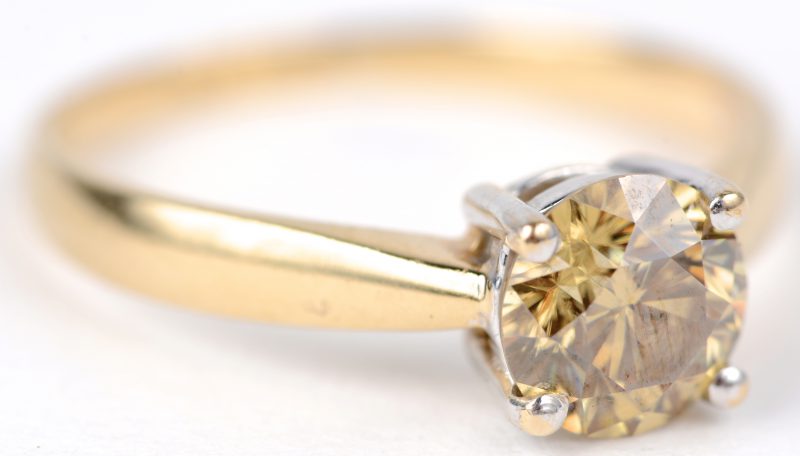 Een 18 karaats wit en geel gouden ring bezet met een fancy diamond van ± 1 ct.