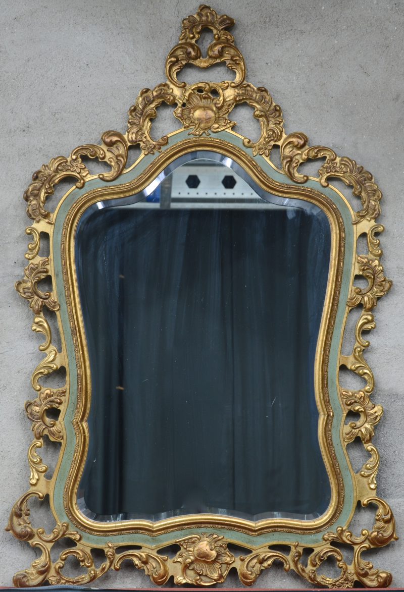 Een spiegel in verguld en deels groengepatineerde houten lijst.