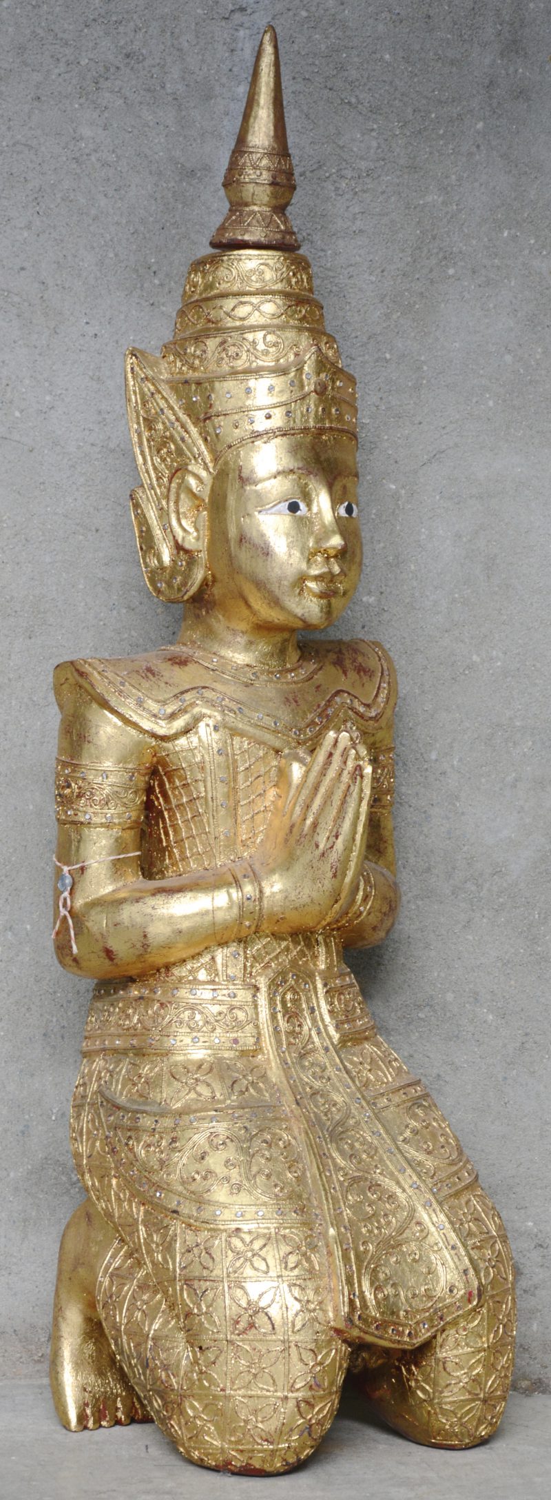 Een knielende Boeddha van goudgepatineerd hout.