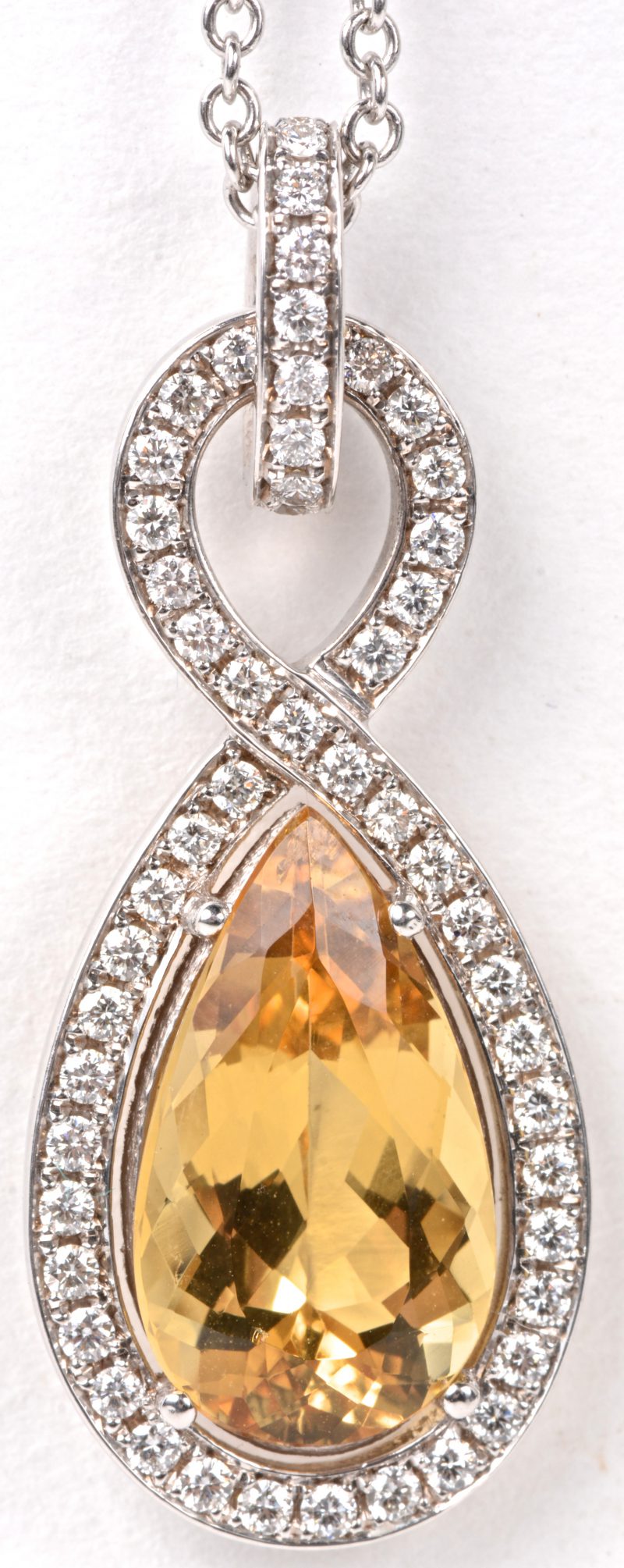 Een 18 karaats wit gouden ketting met hanger bezet diamanten met een gezamenlijk gewicht van ± 0,63 ct. en een in briolette geslepen gele beril van 4,97 ct.