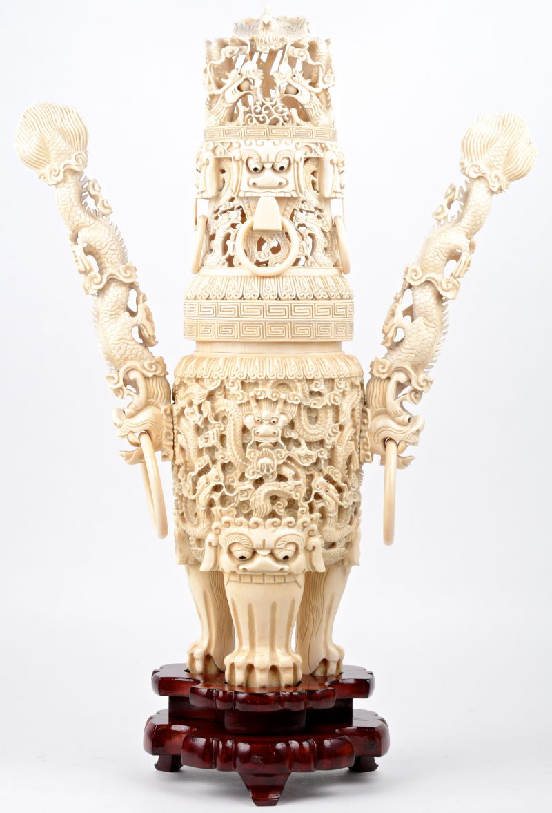 Een Chinese wierookbrander van rijkelijk gesculpteerd ivoor. Op houten sokkel. Gesigneerd.