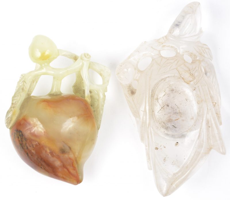 Twee gesculpteerde siervoorwerpen, waarbij één van jade in de vorm van een perzik en één potje met bladermotieven van bergkristal.