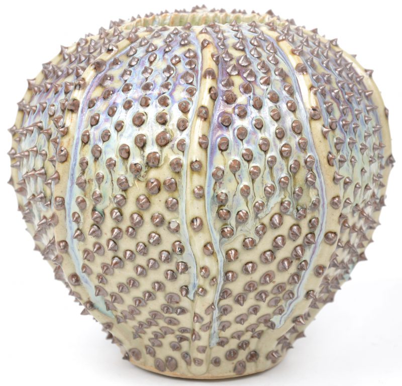 Een merkwaardig aardewerken vaasje in de vorm van een gestilleerde zeeëgel. Gemerkt: “ Des pots”.