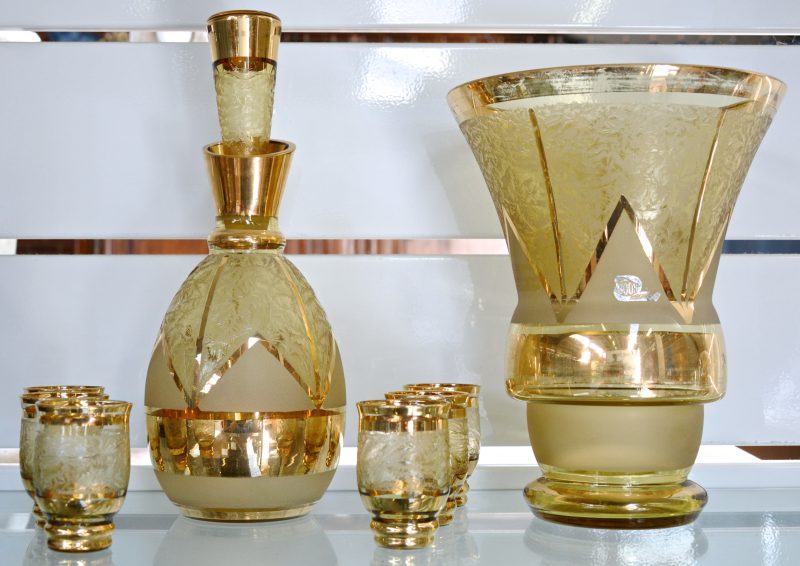 Een vaas, een karaf en zes borrelglaasjes van Booms glas met een verguld decor.