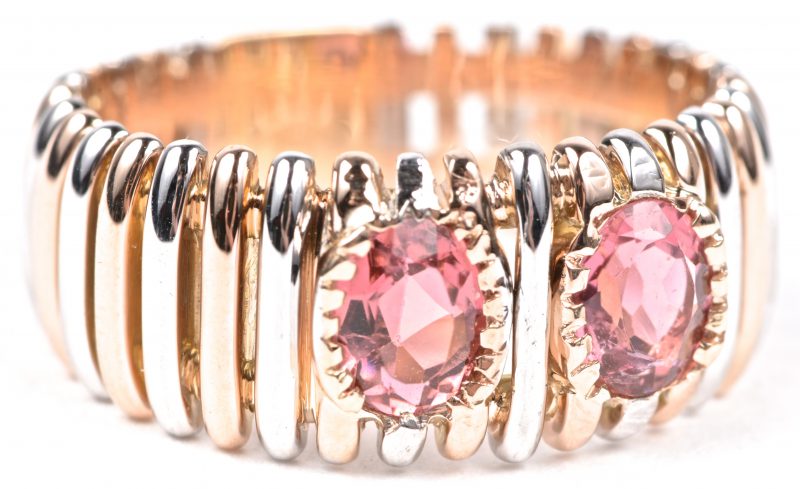 Een 18 karaats wit en geel gouden ring bezet met twee roze saffieren gezamenlijk gewicht van ± 1,09 ct.