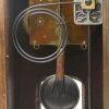 Een houten klokje. Compleet met slinger en sleutel.