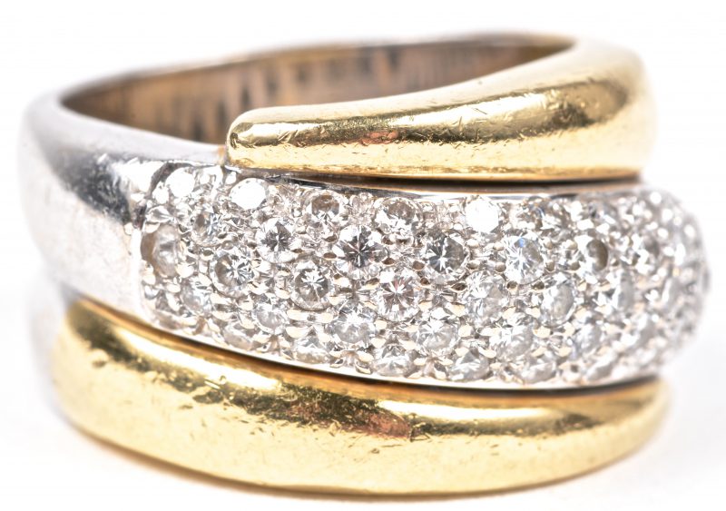 Een 18 karaats wit en geel gouden ring bezet met diamanten met een gezamenlijk gewicht van ± 1 ct.