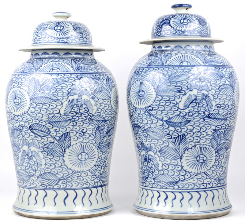 Een paar Chinese dekselvazen met blauw floraal motief.