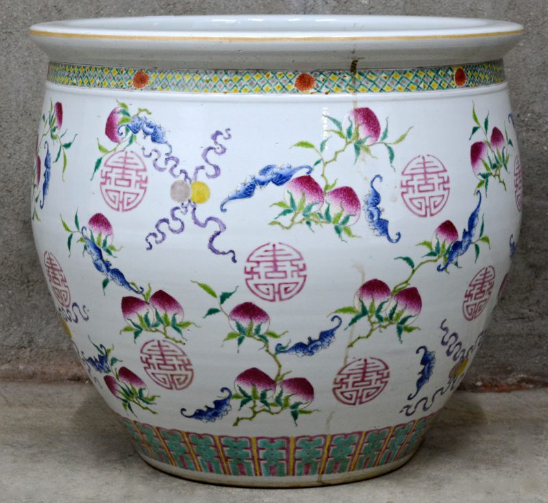 Een Chinese porseleinen cache-pot met florale motieven en tekens.