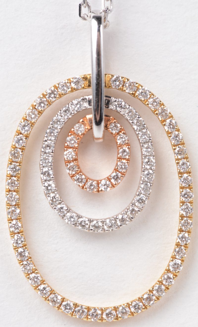 Een 18 karaats wit gouden ketting met drie kleurige hanger bezet met briljanten met een gezamenlijk gewicht van ± 0,64 ct.