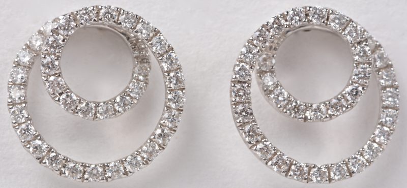 Een paar 18 karaats wit gouden spiraalvormige oorbellen bezet met briljanten met een gezamenlijk gewicht van ± 0,72 ct.