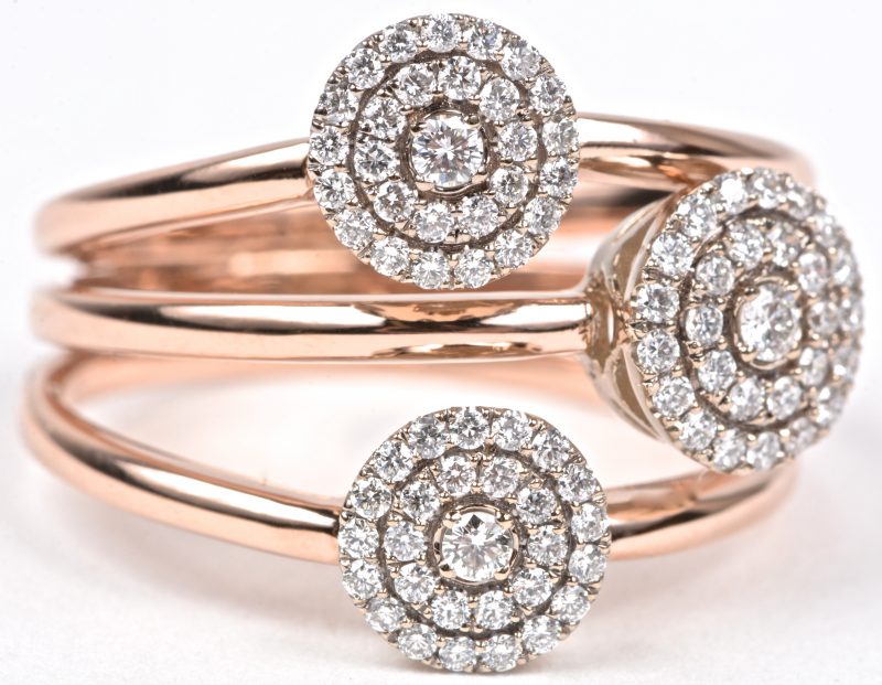 Een 18 karaats wit en roze gouden bloemvormige ring bezet met briljanten met een gezamenlijk gewicht van ± 0,65 ct.