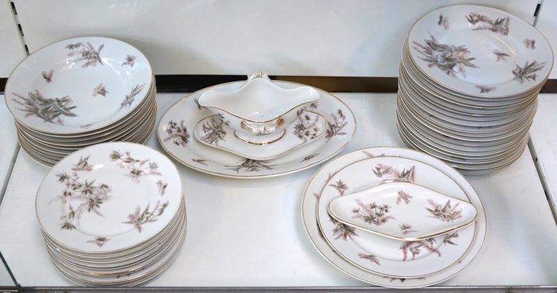 Een servies met een decor van vogeltjes, bestaande uit 29 platte borden en 10 diepe borden, een boterschaaltje, een sauskom, een ronde en een ovale serveerschotel. Gemerkt.