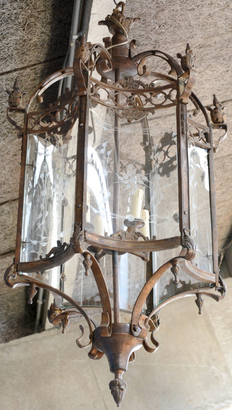 Een grote bronzen hall-lantaarn met bol gegraveerd glas.